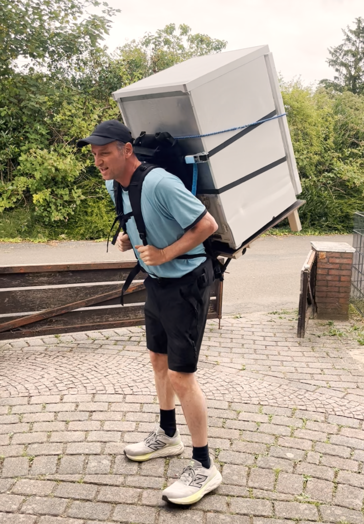Tilo Koch trägt einen Kühlschrank nach Alpe d´Huez